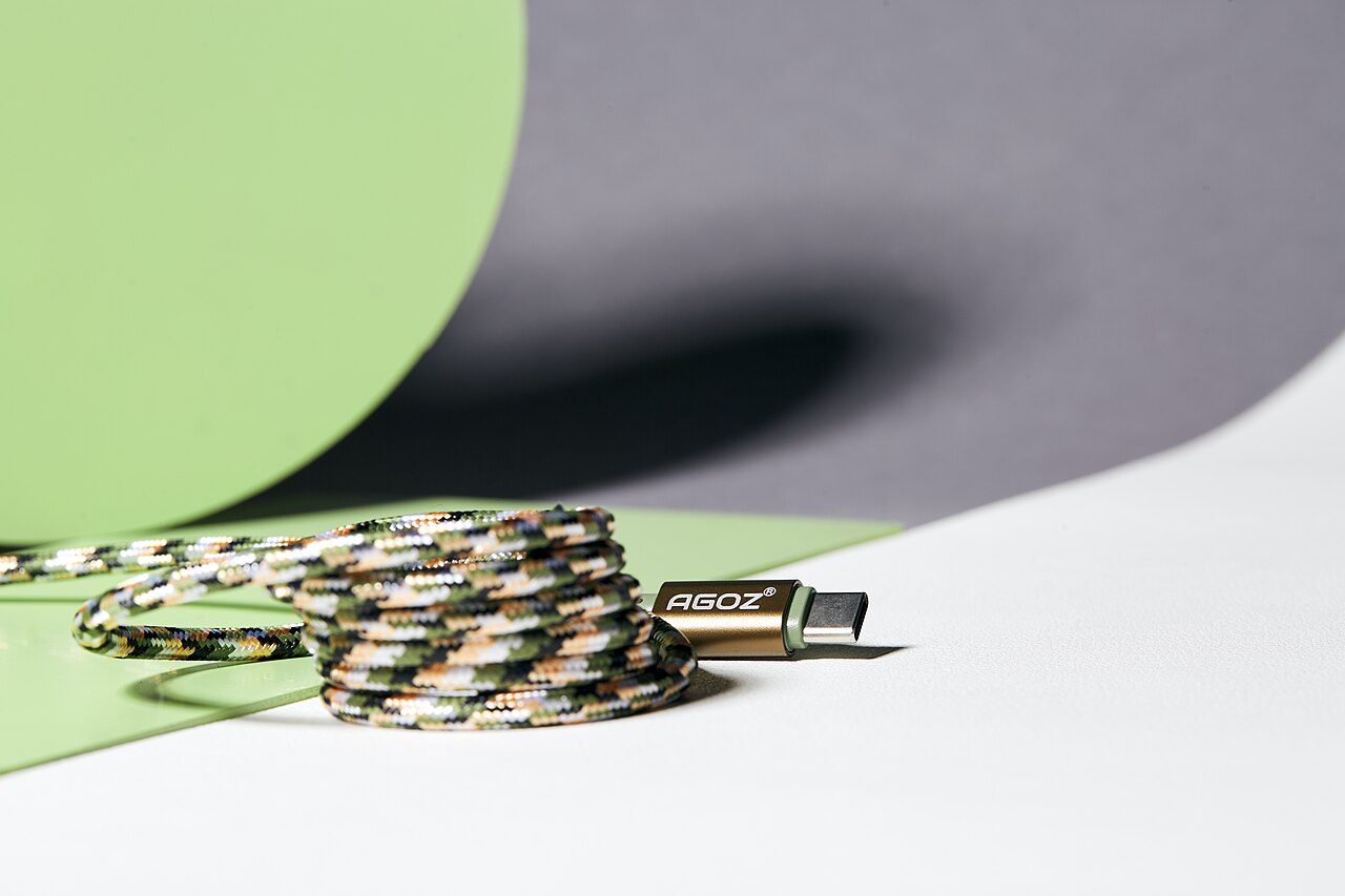 Braided USB-C cable coiled on a desk, connector facing forward