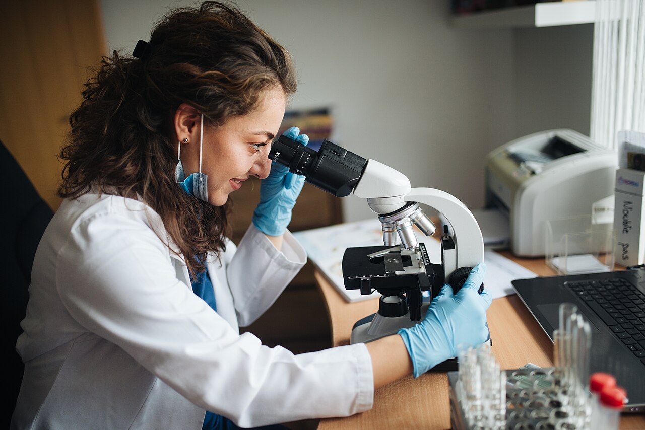 Lab technician using a microscope during medical laboratory research