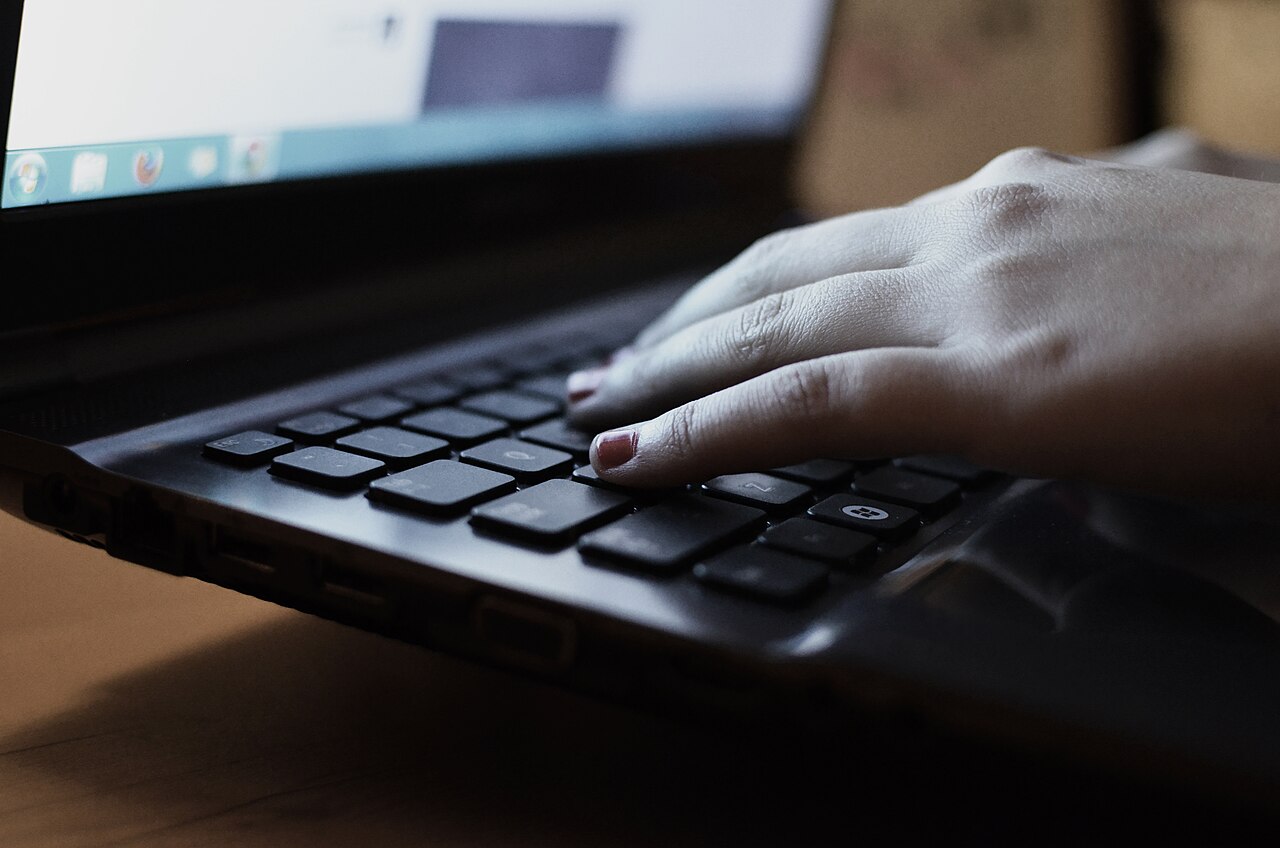 hand typing on laptop while browsing product reviews online