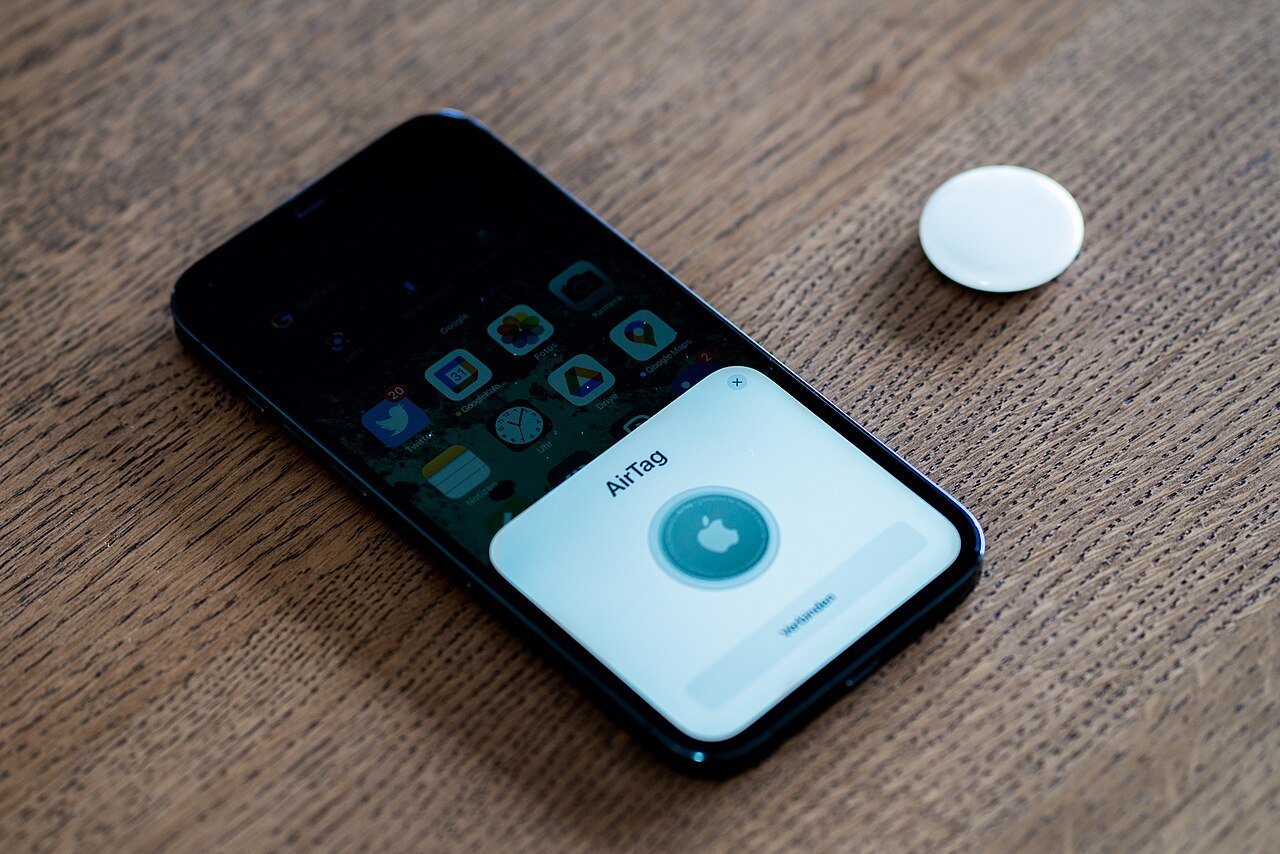Apple AirTag next to iPhone showing the AirTag setup screen, another item in the Apple accessories lineup