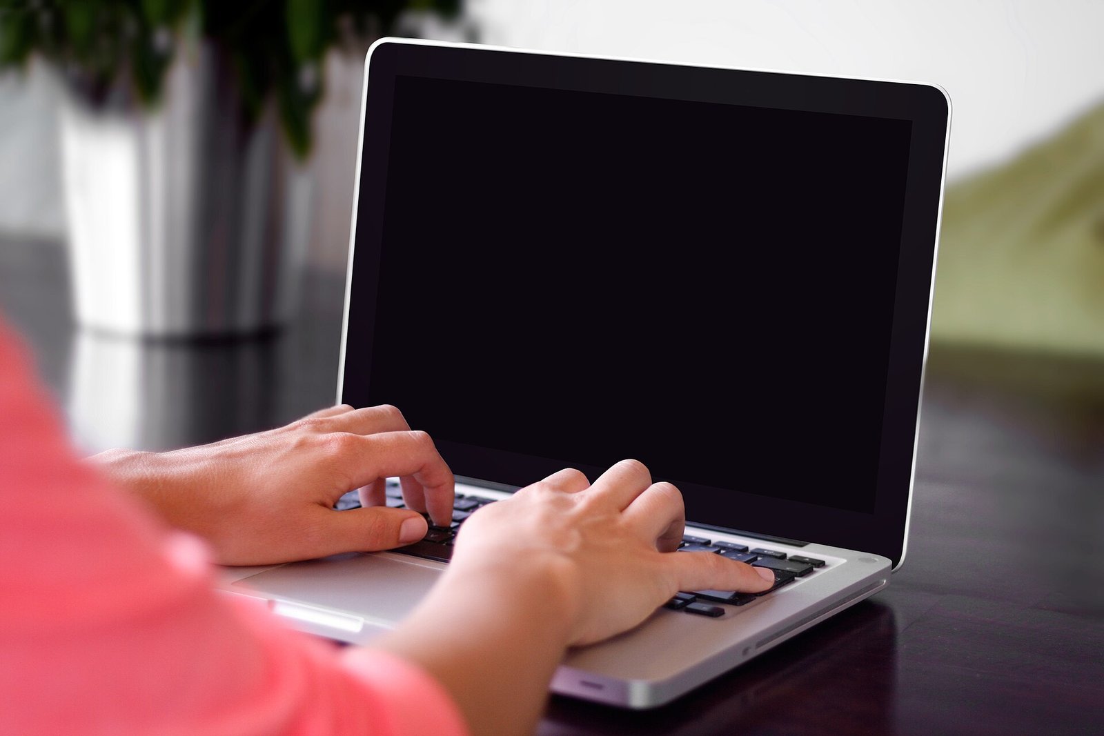 Close-up of hands typing on a laptop keyboard, representative of using AI productivity apps