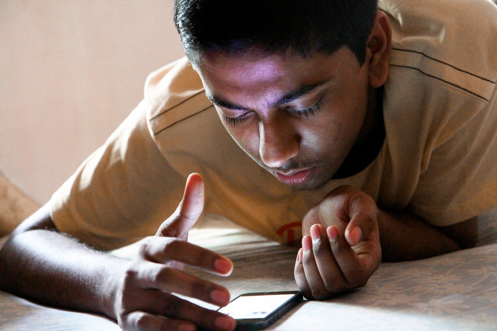 Teenager closely focused on smartphone screen, representing ChatGPT for Teens parental controls context