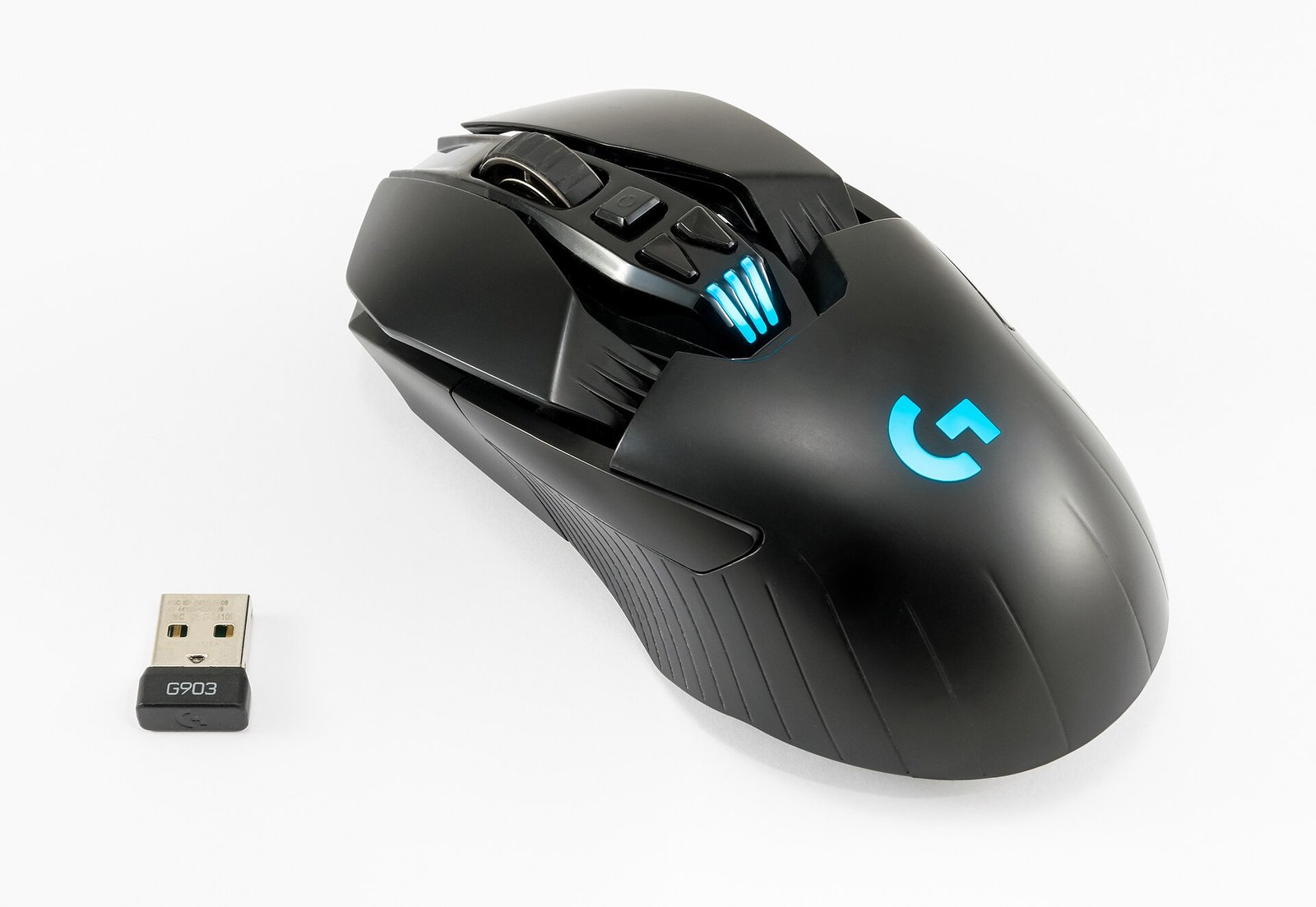 Logitech G903 Lightspeed wireless gaming mouse next to its small USB RF receiver dongle, illustrating RF wireless mouse technology