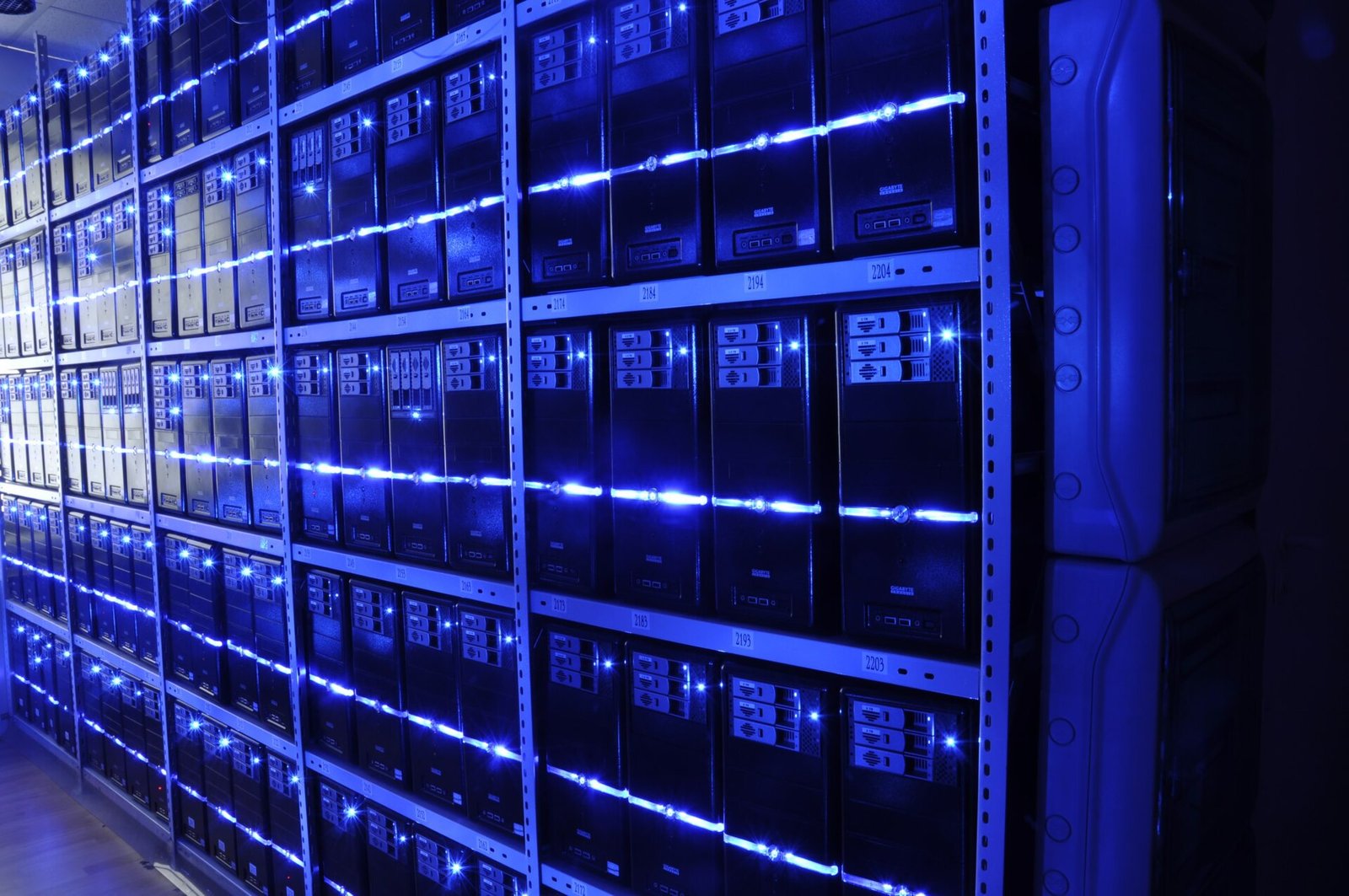 Rows of server racks with blue status LEDs in a data center, representing the AI compute infrastructure behind Nvidia's chip deals