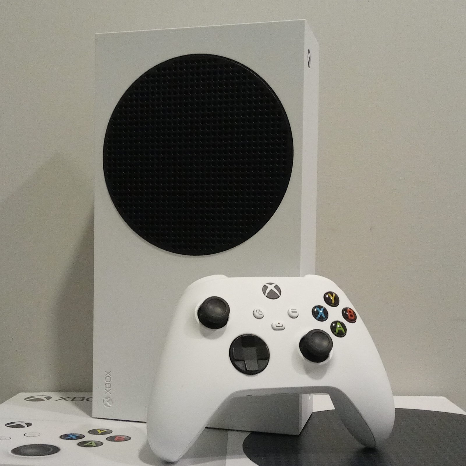 Xbox Series S console standing next to its wireless controller