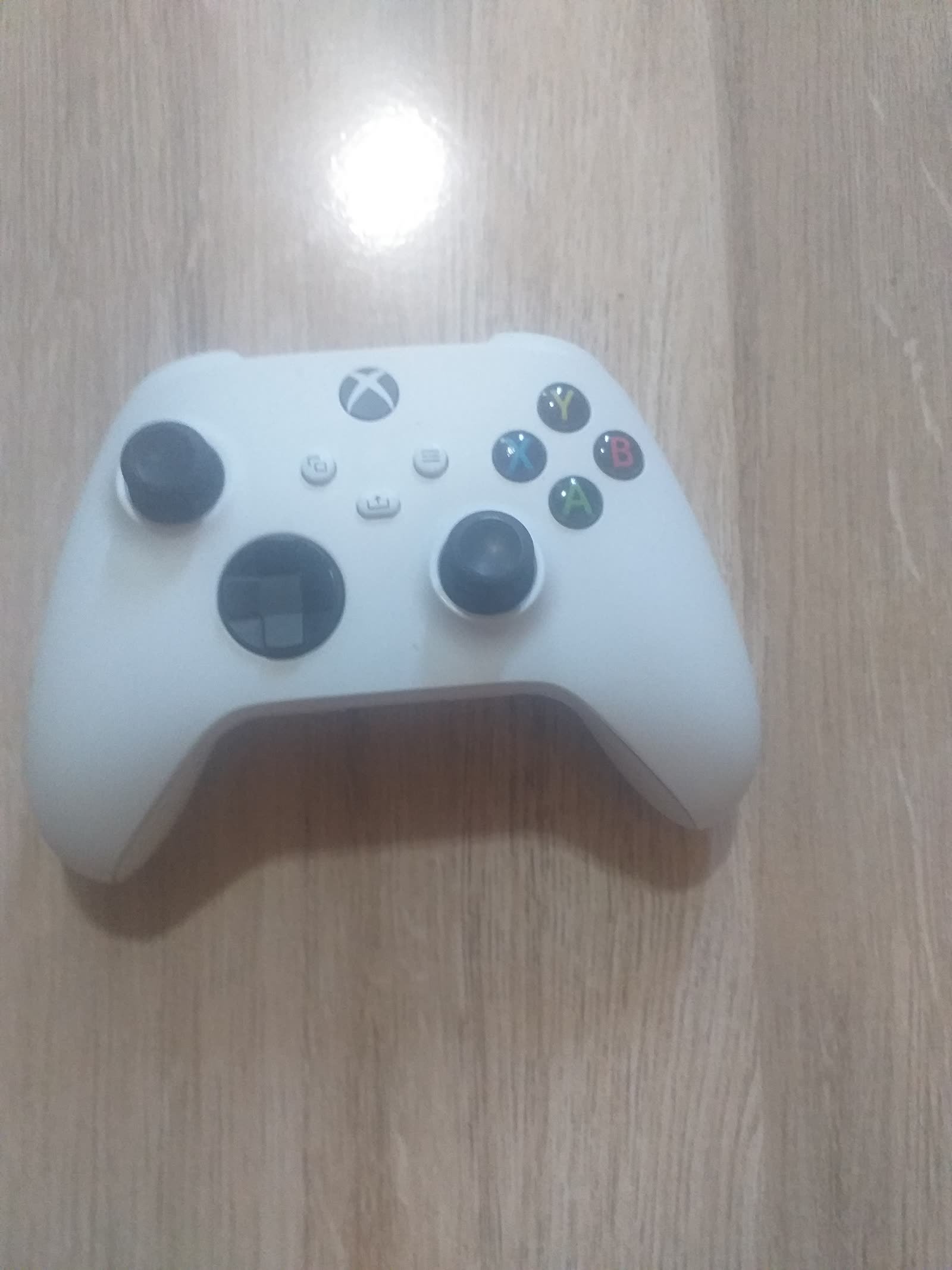 Close-up of a white Xbox wireless controller with A, B, X, Y buttons and Xbox logo